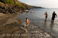 Banyant-se a la platja de sorra negra de Ho'okena. Illa Gran.